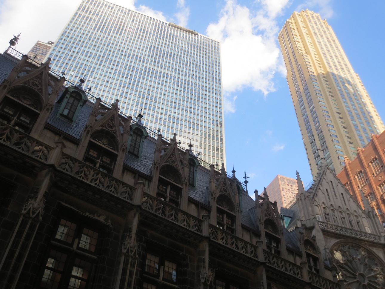 An older building below newer skyscrapers.