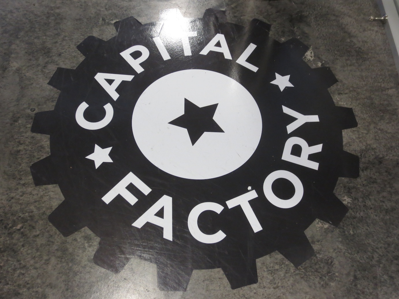 The logo for Capital Factory on the floor of their working space