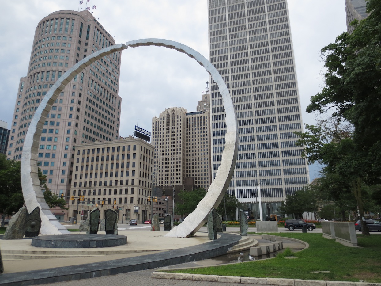 Artwork in a park on the river looking up at the buildings downtown.