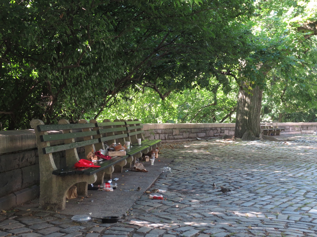 Garbage piling up on a park bench on the Upper West Side.