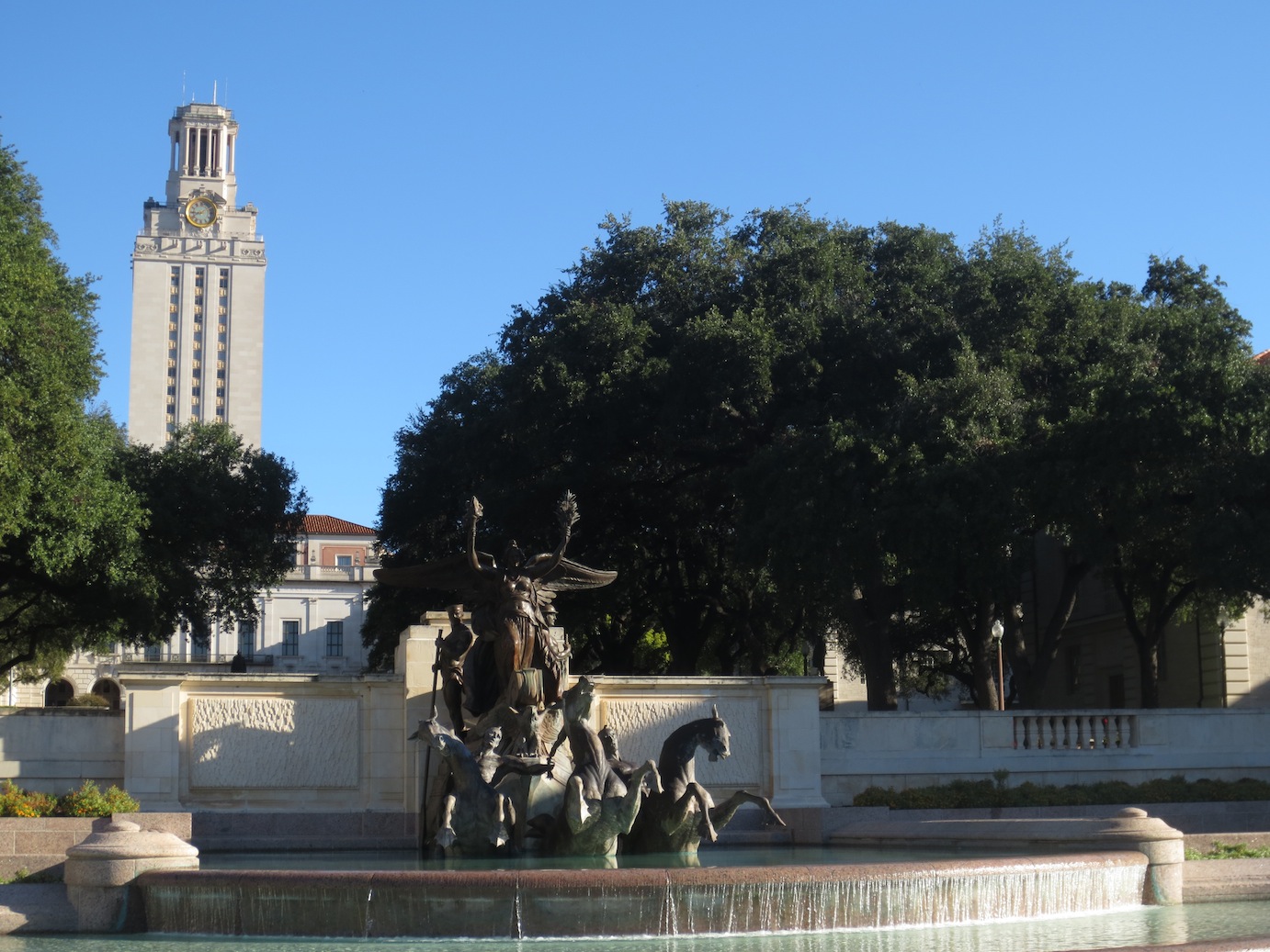 Fountain statue with the UT-Austin Bell Tower in the background.
